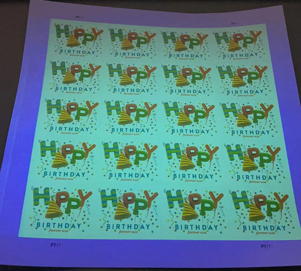 Happy Birthday Forever stamp sheet under ultraviolet light