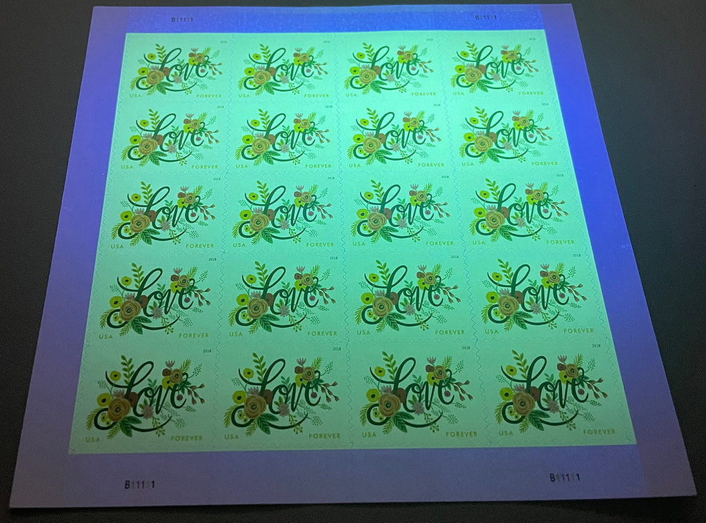 Love Flourishes stamp sheet under ultraviolet authentication light